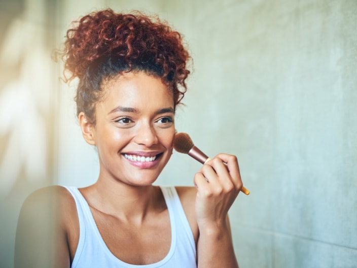 ragazza che applice il bronzer