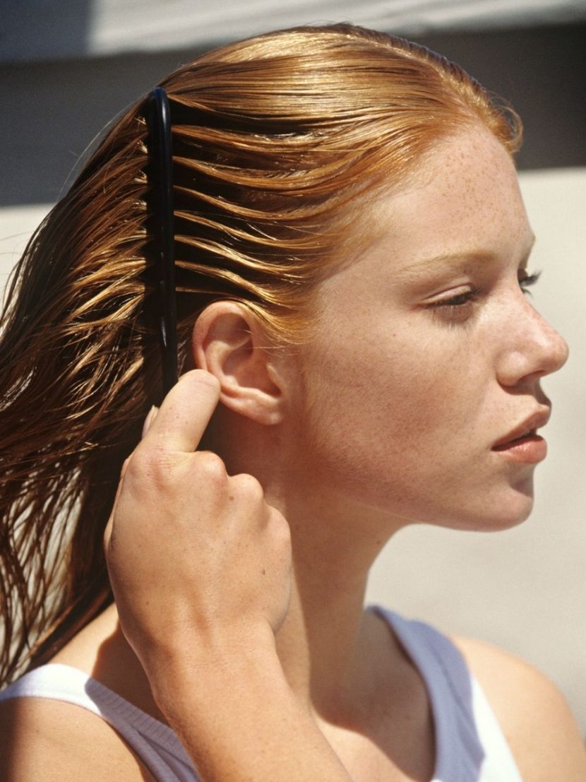 ragazza pettina i capelli lisci bagnati