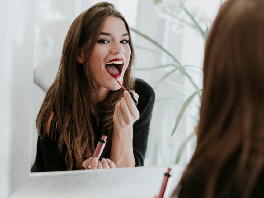 ragazza applica il rossetto