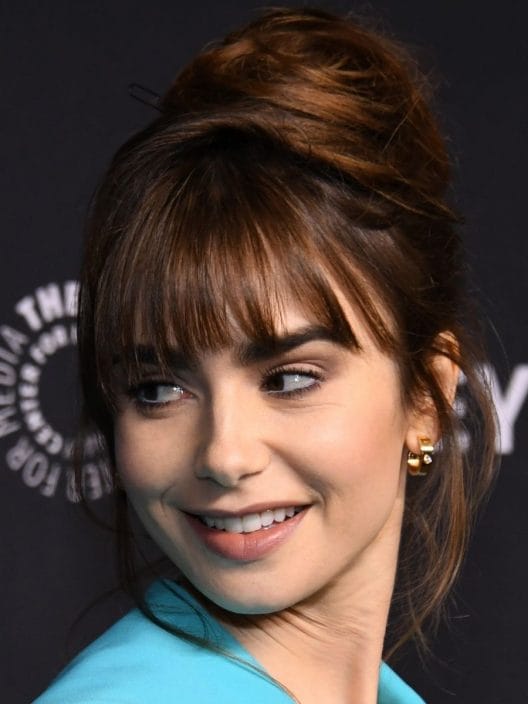 Lo chignon alto di Lily Collins ci ricorda Audrey Hepburn. Ed è super chic